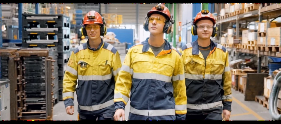 Three manufacturing employees walking through a production facility