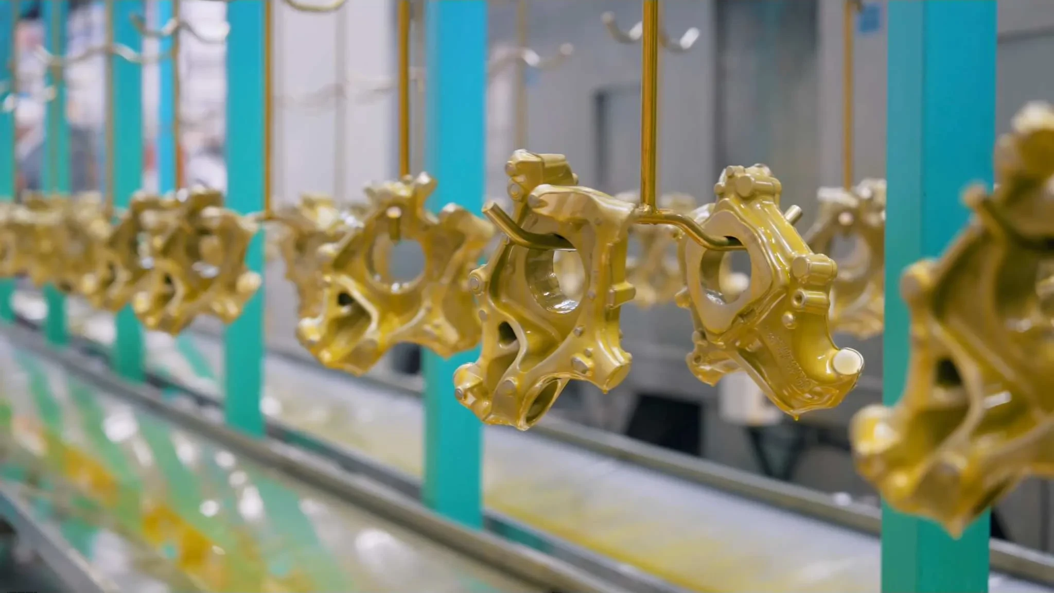 Rows of machined brass components moving along a production line in a manufacturing plant